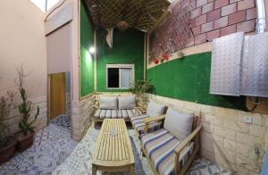 una habitación con bancos y una pared verde en FIFI maison, en Ouarzazate