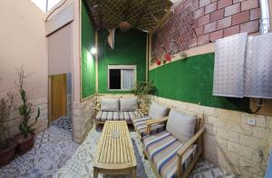 a room with benches and a green wall at FIFI maison in Ouarzazate