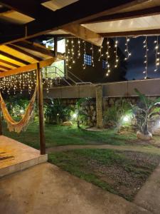 a patio with a hammock in a yard with lights at Chalé Canto do Galo in Ilhabela