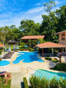 una piscina en un complejo con piscinas azules y sombrillas en Bungalows Malú, en Cahuita