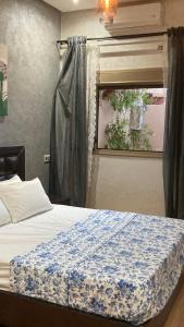1 dormitorio con 1 cama con manta azul y blanca en FIFI maison, en Ouarzazate