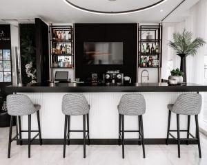 un bar con tres taburetes en una habitación en Benavente Vila Hotel, en Benavente