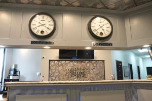 dwa zegary na ścianie poczekalni w obiekcie American Inn & Suites w mieście Waterford