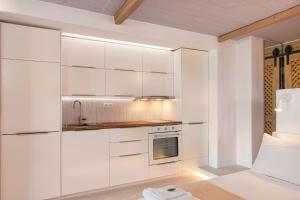 Chariclea Villa في ساموس: مطبخ أبيض مع دواليب بيضاء ومغسلة