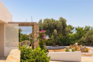 un jardín con flores rosas y un edificio en Chariclea Villa en Samos