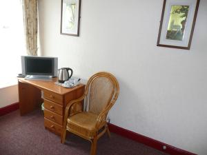 a room with a desk with a computer and a chair at Beijing Dragon Hotel in Spilsby