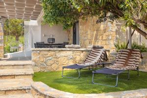 2 Stühle und ein Tisch im Hof in der Unterkunft Chariclea Villa in Samos