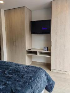 - une chambre avec un lit et une télévision à écran plat dans l'établissement Apartamento Chic en el corazón de Bogotá, à Bogotá