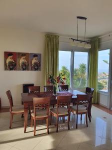 a dining room with a table and chairs and windows at Agnanti Villas in Agia Pelagia