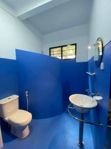 La salle de bains bleue est pourvue de toilettes et d'un lavabo. dans l'établissement Pearl Villa Rooms and Hostel, à Unawatuna