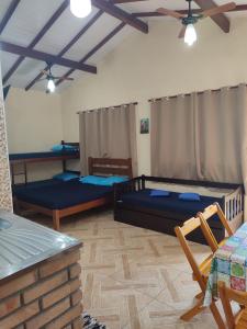 sala de estar con 3 camas y techo en Chalé Canto do Galo, en Ilhabela