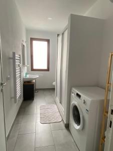 uma lavandaria com uma máquina de lavar roupa e um lavatório em Il Sole Verde em Marrùbiu