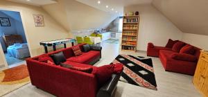 a living room with two red couches and a rug at Boldogfalvi apartman in Debrecen