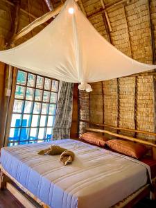 a bedroom with a bed with a canopy and windows at Lanta Marina Resort By Mam&Mod in Ko Lanta