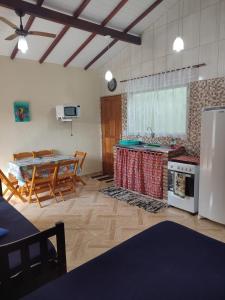 a kitchen and dining room with a table and a refrigerator at Chalé Canto do Galo in Ilhabela