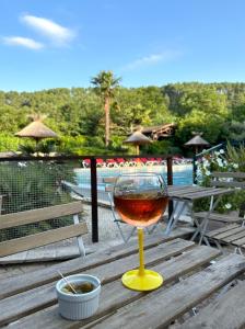 een glas wijn bovenop een houten tafel bij Hameau du Prat in Ribes