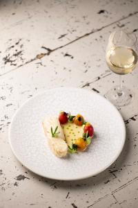 a white plate with food and a glass of wine at The Old Deanery - Restaurant With Rooms in Ripon