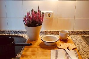 a table with a vase of flowers and two cups at La Cabaña de Llívia, Cerdanya, Puigcerdà. in Llivia