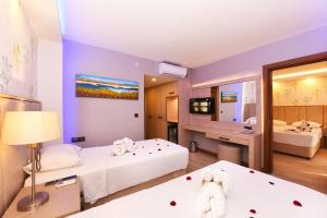 a bedroom with two beds and a bathroom with a tub at Sundia By Liberty Oludeniz in Oludeniz