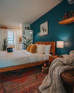 een slaapkamer met een groot bed met blauwe muren bij Willow Pond Motel in Catskill