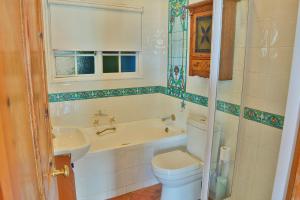 La salle de bains est pourvue de toilettes, d'une baignoire et d'un lavabo. dans l'établissement Oupa se Pitte, à Herolds Bay