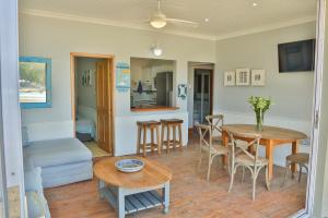 uma sala de estar com mesa e cadeiras em Oupa se Pitte em Herolds Bay