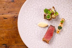 a white plate with food on a wooden table at The Old Deanery in Ripon