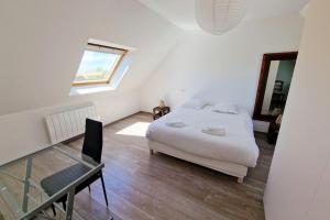 a bedroom with a bed and a desk and a window at Ty Colo ✿ maison familiale classée, proche Brest in Saint-Renan