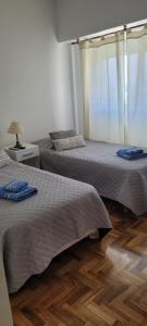 2 camas en un dormitorio con suelo de madera en Apartamento en el centro de Lomas en Lomas de Zamora