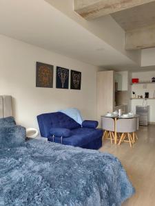una camera con un letto blu e un divano di Apartamento Chic en el corazón de Bogotá a Bogotá