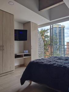波哥大的住宿－Apartamento Chic en el corazón de Bogotá，一间卧室设有一张大床和一个大窗户