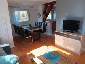 a living room with a dining table and a television at Superbe gite au centre de Kaysersberg avec 3 chambres in Kaysersberg