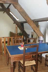 une table à manger avec des chaises et une table bleue dans l'établissement Le p'tit hameau de Sey, à Quettehou