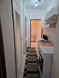 una pequeña cocina con armarios blancos y fregadero en Central City Apartment, en Viena