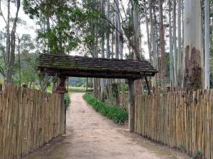 uma cerca de madeira com um arco de madeira sobre uma estrada de terra em Bangalô sobre o lago no Vale das Videiras em Petrópolis