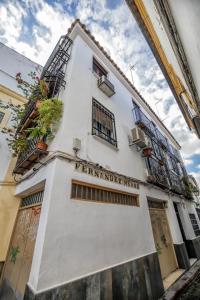 a white building with windows and plants on it at Zafiro Apartment&Parking in the historical centre in Córdoba