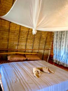 a bed in a straw hut with two animals laying on it at Lanta Marina Resort By Mam&Mod in Ko Lanta
