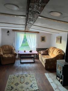 uma sala de estar com dois sofás e uma mesa em Etno kuća Milidrag em Foca