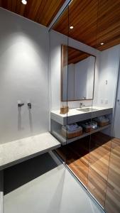 uma casa de banho com um lavatório e um espelho em Bangalô sobre o lago no Vale das Videiras em Petrópolis