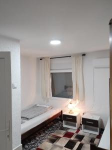 a white room with a bed and a window at Loznica, Venera sobe in Ploča