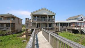 a row of houses on a wooden boardwalk at OCEANFRONT, Ocean Views, Private Beach Access, Sun Decks, KD229, The Sand Trap in Kill Devil Hills