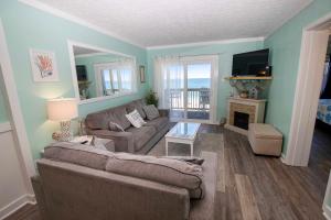 a living room with a couch and a fireplace at OCEANFRONT, Community Pool and beach walkway! KD220, Feelin Nauti in Kill Devil Hills