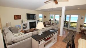 a living room with a couch and a tv at OCEANFRONT, Ocean Views, Private Beach Access, Sun Decks, KD229, The Sand Trap in Kill Devil Hills