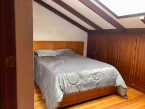 um quarto com uma cama e armários de madeira em Cosita Linda - Departamento familiar 3 hab. em Cuenca