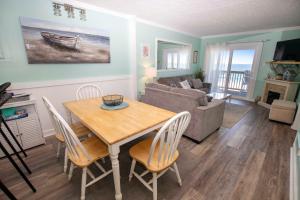 a living room with a table and chairs and a couch at OCEANFRONT, Community Pool and beach walkway! KD220, Feelin Nauti in Kill Devil Hills