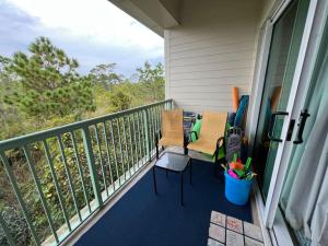 a balcony with chairs and tables on a porch at Lovely 3-bedroom beach condo! Walk to shop or eat! in Pensacola