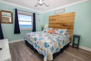 a bedroom with a bed with a wooden headboard and a window at OCEANFRONT, Community Pool and beach walkway! KD220, Feelin Nauti in Kill Devil Hills