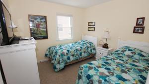 a bedroom with two beds and a tv in it at OCEANFRONT, Ocean Views, Private Beach Access, Sun Decks, KD229, The Sand Trap in Kill Devil Hills