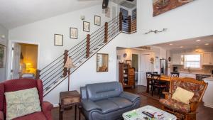 ein Wohnzimmer mit Stühlen und einer Treppe in der Unterkunft KD231, WindOver- Oceanside, Hot Tub, Close to beach in Kill Devil Hills