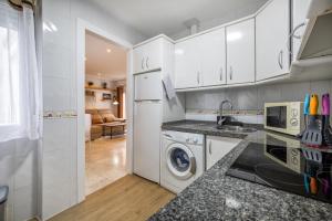 a kitchen with white cabinets and a washer and dryer at Zafiro Apartment&Parking in the historical centre in Córdoba